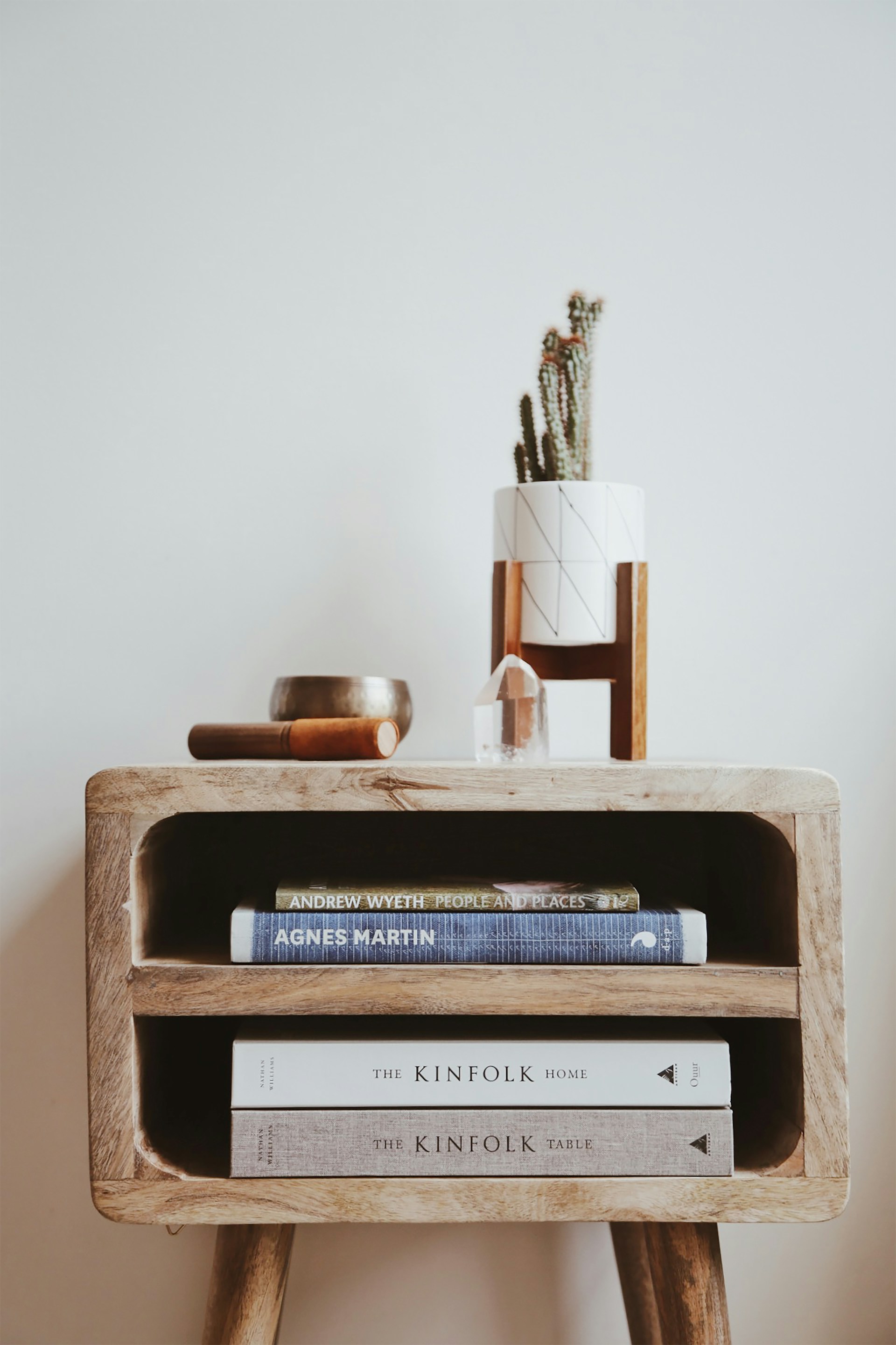 A styled table with books, ceramics and a vase